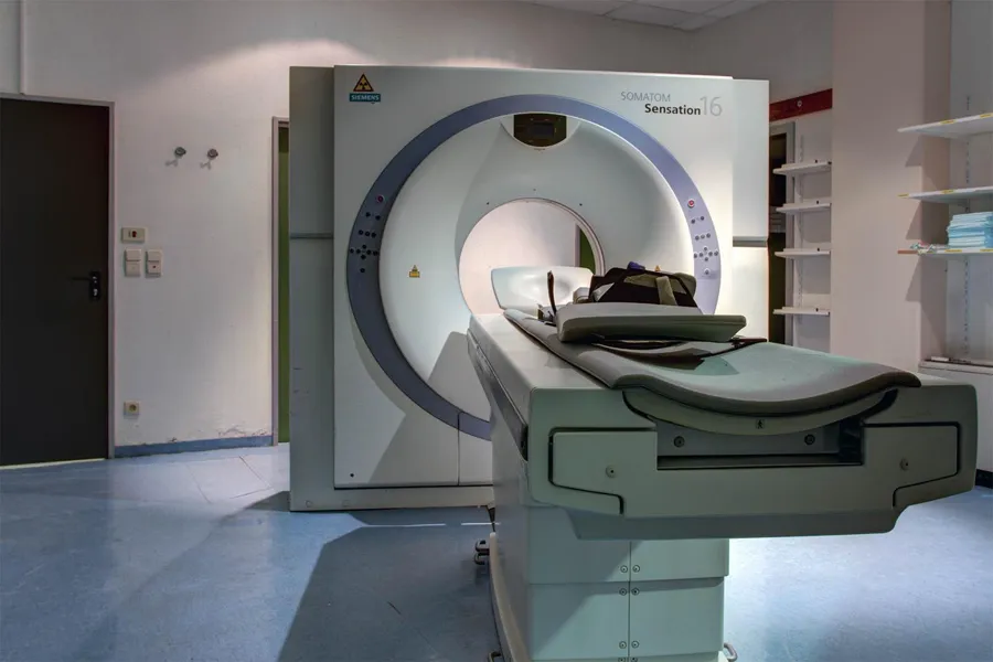 CT scanner with an extending patient table in a disused room.