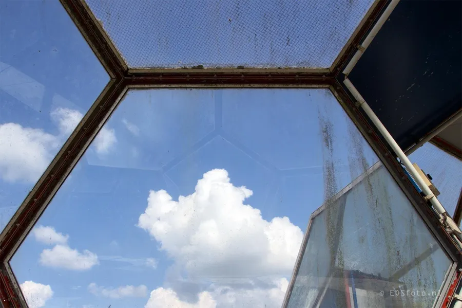 Ciel bleu et nuages à travers une fenêtre hexagonale