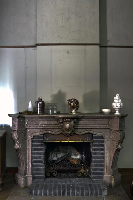 Chimenea de mármol con pequeños objetos sobre la repisa