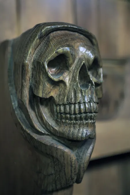 Detalle de calavera tallada en madera oscura.