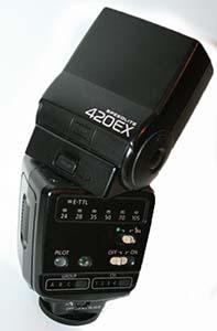 Canon Speedlite 420EX schräg von hinten mit nach oben geneigtem Blitzkopf und sichtbaren Bedienelementen.