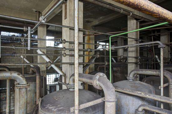 Metallbehälter und Rohre hinter einem Stahlgeländer