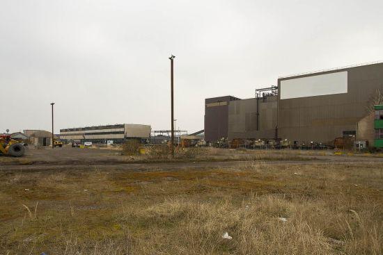 Wide factory building with vacant ground and dry grass in front