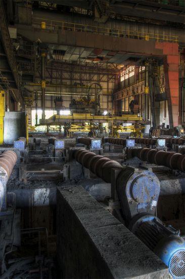 Rows of round metal components inside a long factory hall