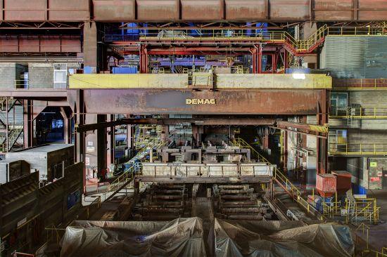 Demag overhead crane above equipment and a large tarpaulin-covered vessel