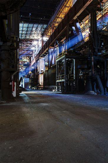 Long empty passage beneath pipes and high steelwork