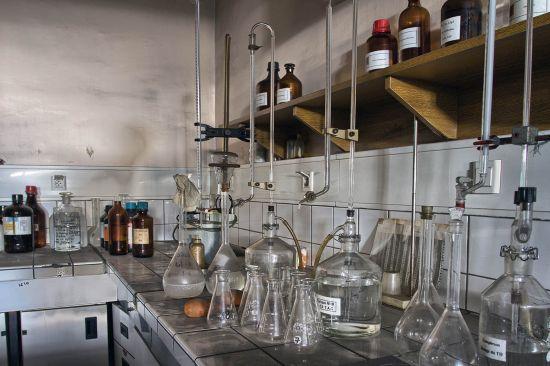 Glaskolben und Leitungen auf einem gefliesten Arbeitstisch