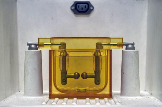 Gerät mit zwei Metallröhren hinter einer gelben Scheibe