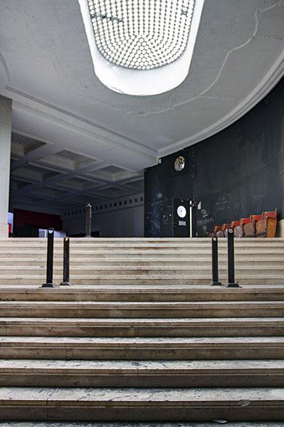 Breite Treppe unter einer ovalen Deckenöffnung mit Gitter
