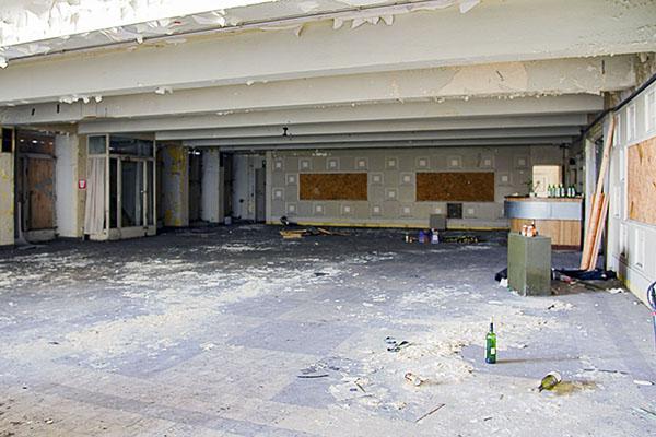 Leeres verfallenes Foyer mit beschädigten Wänden und Boden